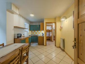 a kitchen with green cabinets and a table in a room at Apartment Abete by Interhome in Rabbi