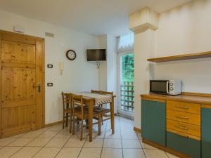 a kitchen with a table and chairs and a microwave at Apartment Abete by Interhome in Rabbi