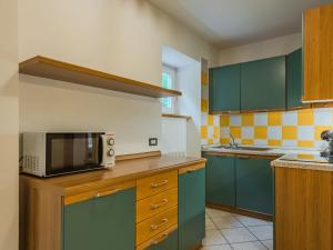 a kitchen with green cabinets and a microwave at Apartment Abete by Interhome in Rabbi +11 photos