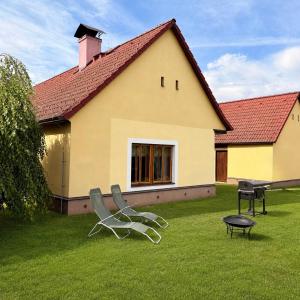 two chairs and a table in the yard of a house at Škorničkův statek - chalupa Andělka s wellness za příplatek in Hamr +15 photos