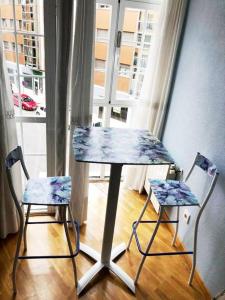 a table and two chairs in front of a window at Villaviciosa in Villaviciosa