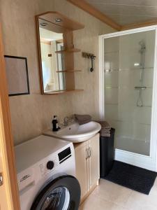 a bathroom with a washing machine and a sink at Het Kempens huisje in Lille