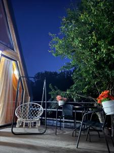 a table and chairs on a balcony at night at Tlughi cottage in Obcha