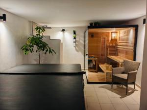 a room with a table and a chair and a kitchen at Škorničkův statek - chalupa Andělka s wellness za příplatek in Hamr