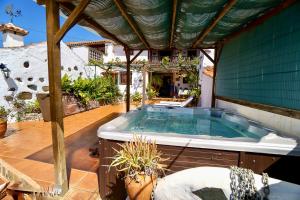 a hot tub on a patio with a pergola at Casa Rural Guiniguada in Santa Brígida