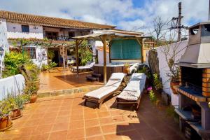 a patio with chaise lounges and a fireplace at Casa Rural Guiniguada in Santa Brígida
