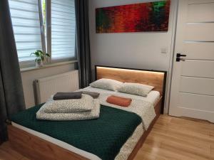 a bedroom with a bed with two pillows on it at Apartments Częstochowa - Nova Bursa - Prywatny parking! in Częstochowa