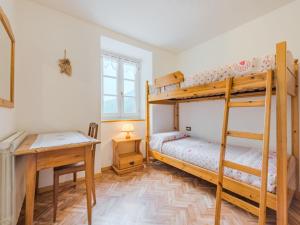 a bedroom with two bunk beds and a desk at Apartment Abete e Betulla by Interhome in Rabbi