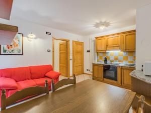 a living room with a red couch in a kitchen at Apartment Abete e Betulla by Interhome in Rabbi
