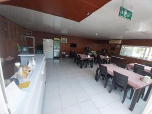 an empty restaurant with tables and chairs and a kitchen at London House Hotel in Kemer