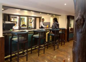 a man and a woman standing at a bar at The Treetops Lodge in Nyeri