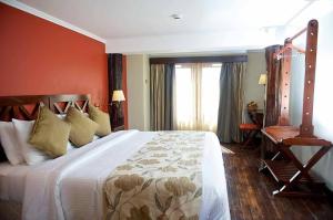 a bedroom with a large bed with orange walls at The Treetops Lodge in Nyeri