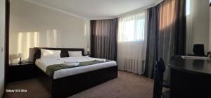 a hotel room with a bed and a window at Archa hotel in Osh +9 photos