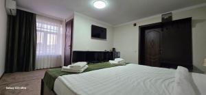 a bedroom with a large bed with two towels on it at Archa hotel in Osh