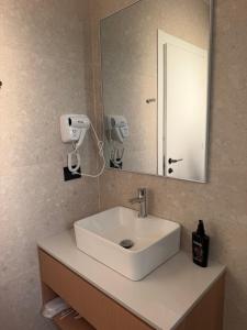 a bathroom with a white sink and a mirror at Soléa Himara Guesthouse in Himare