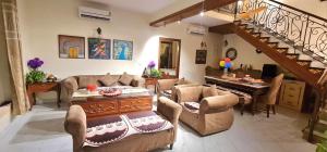 a living room with a couch and a piano at Vedic village Rai villa in Sikarpur
