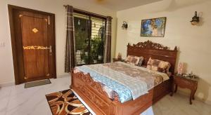 a bedroom with a large wooden bed and a window at Vedic village Rai villa in Sikarpur +98 photos