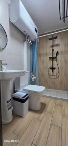 a bathroom with a white toilet and a sink at Archa hotel in Osh