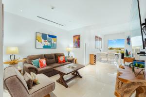 a living room with a couch and a table at 2 BR Oceanview Condo Coral Shell 3e in Oranjestad
