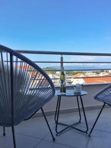 una silla y una mesa con una copa de vino en el balcón en Luxury penthouse with sea view, en Makarska