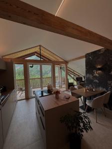 a kitchen and living room with a table and chairs at Collis Hill Chalets & Hotel in Kals am Großglockner