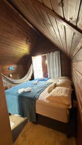 a bedroom with a bed in a wooden room at Chalé Entre Ciclos Icaraizinho in Amontada