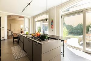 a kitchen with a stove and a large window at Maison Martina in Rivoli