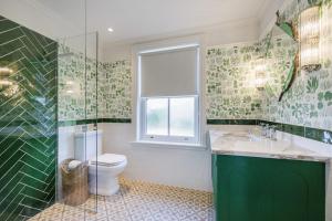 a bathroom with a toilet and a sink and a window at Sandown, Spacious and Stylish in Southwold in Southwold +30 photos