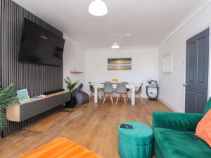 a living room with a green couch and a table at Ty Haul in Rhosneigr
