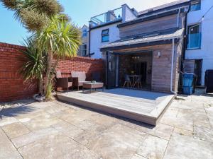 a house with a patio and a brick wall at Ty Haul in Rhosneigr
