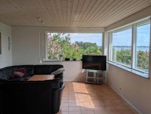a living room with a couch and a flat screen tv at FJ1603-Jaegerspris-Kystsvinget-3 in Jægerspris