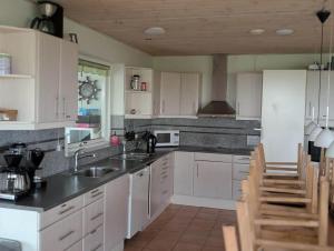 a kitchen with white cabinets and black counter tops at FJ1603-Jaegerspris-Kystsvinget-3 in Jægerspris