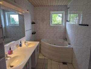 a bathroom with a tub and a sink and a tub and a bath tub at FJ1603-Jaegerspris-Kystsvinget-3 in Jægerspris +20 photos