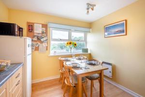 a kitchen with a table with chairs and a refrigerator at 2 Bed in Bamburgh oc-nb282 in Bamburgh