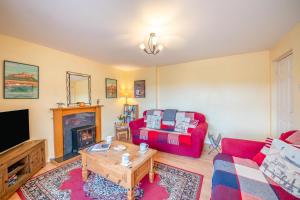 a living room with a red couch and a fireplace at 2 Bed in Bamburgh oc-nb282 in Bamburgh