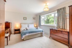a bedroom with a bed and a window and a dresser at 4 Bed in Halesworth oc-willho in Halesworth