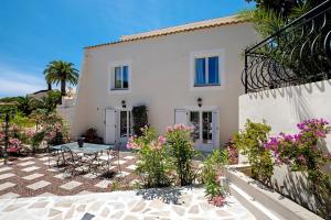 a white house with chairs and flowers in front of it at Villa Belle Epoque Saint-Raphaël in Saint-Raphaël