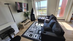 a living room with a couch and a tv at Heavenly Rest by JC in Edmonton