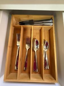 a wooden box with spoons and forks in it at Villadeco Escape, Gated Cottage with Generator in West End