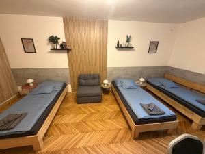 a room with two beds and a chair in it at Carlos Apartman Kecskemét in Kecskemét