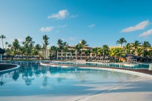 a swimming pool at a resort with palm trees at Iberostar Waves Bahia - All Inclusive in Praia do Forte