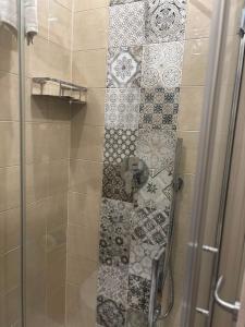 a shower with a glass door with a tile floor at Matera Central Nest in Matera