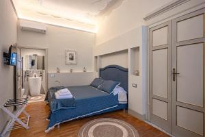 ein Schlafzimmer mit einem blauen Bett und ein Badezimmer in der Unterkunft Casa Ciseri in Siena