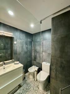a bathroom with a toilet and a sink and a mirror at Os Marias in Tomar