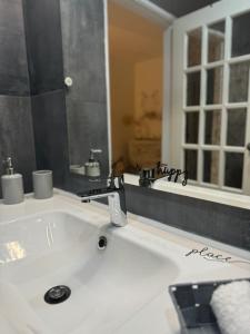 a bathroom sink with a faucet and a mirror at Os Marias in Tomar