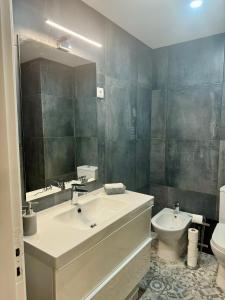 a bathroom with a sink and a toilet and a mirror at Os Marias in Tomar