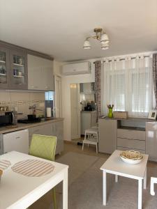 a kitchen with white cabinets and a white table at Apartman Lala in Nova Varoš