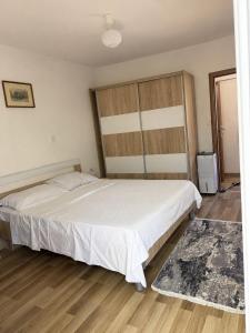 a bedroom with a large white bed and wooden floors at The Lakehouse in Krnjice