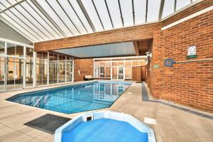 a swimming pool in a building with a brick wall at Milton House Group Retreats in Bedford