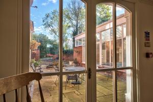 an open glass door looking out onto a patio at Milton House Group Retreats in Bedford